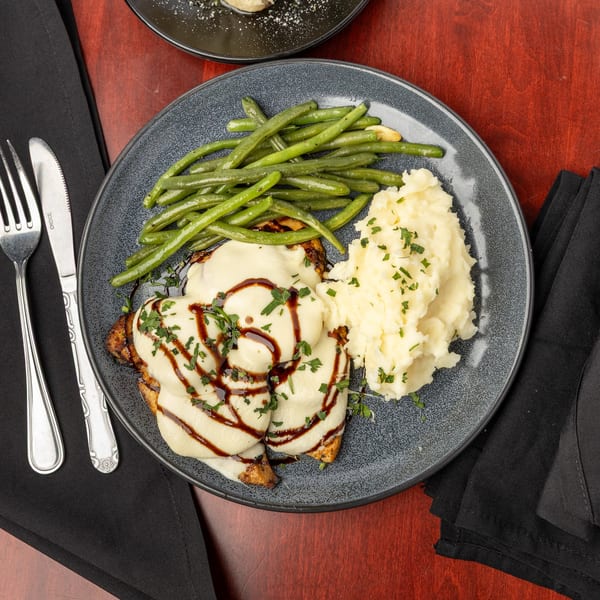 Capo & Co.'s chicken dish with melted cheese, balsamic glaze, green beans, and mashed potatoes.